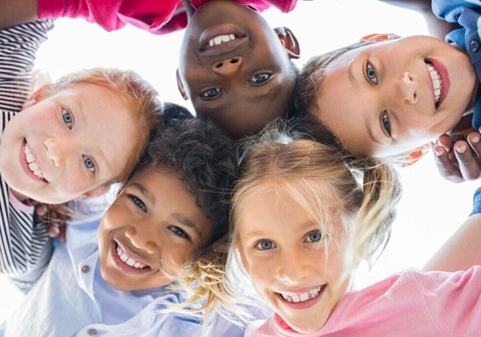 A group of children are smiling for the camera.
